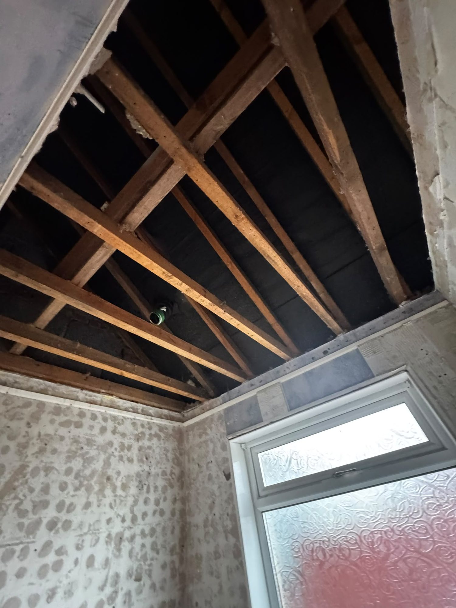 Ceiling stripped back to joists during asbestos removal in Anglesey