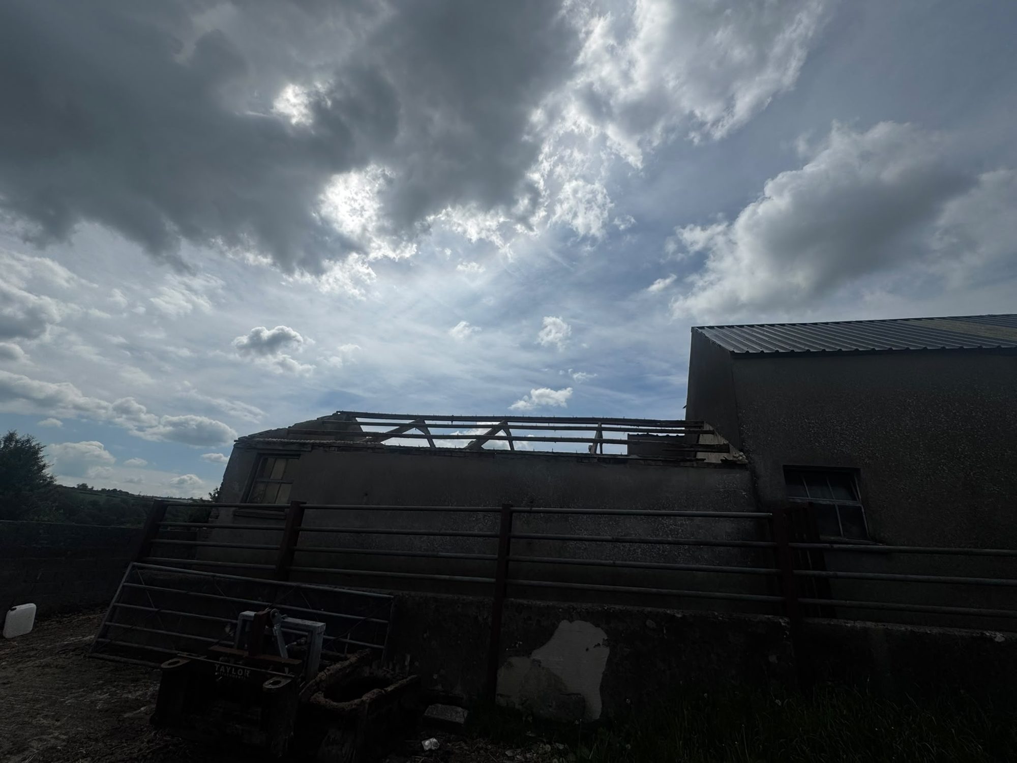 Agricultural barn with roof partly stripped during demolition in North Wales