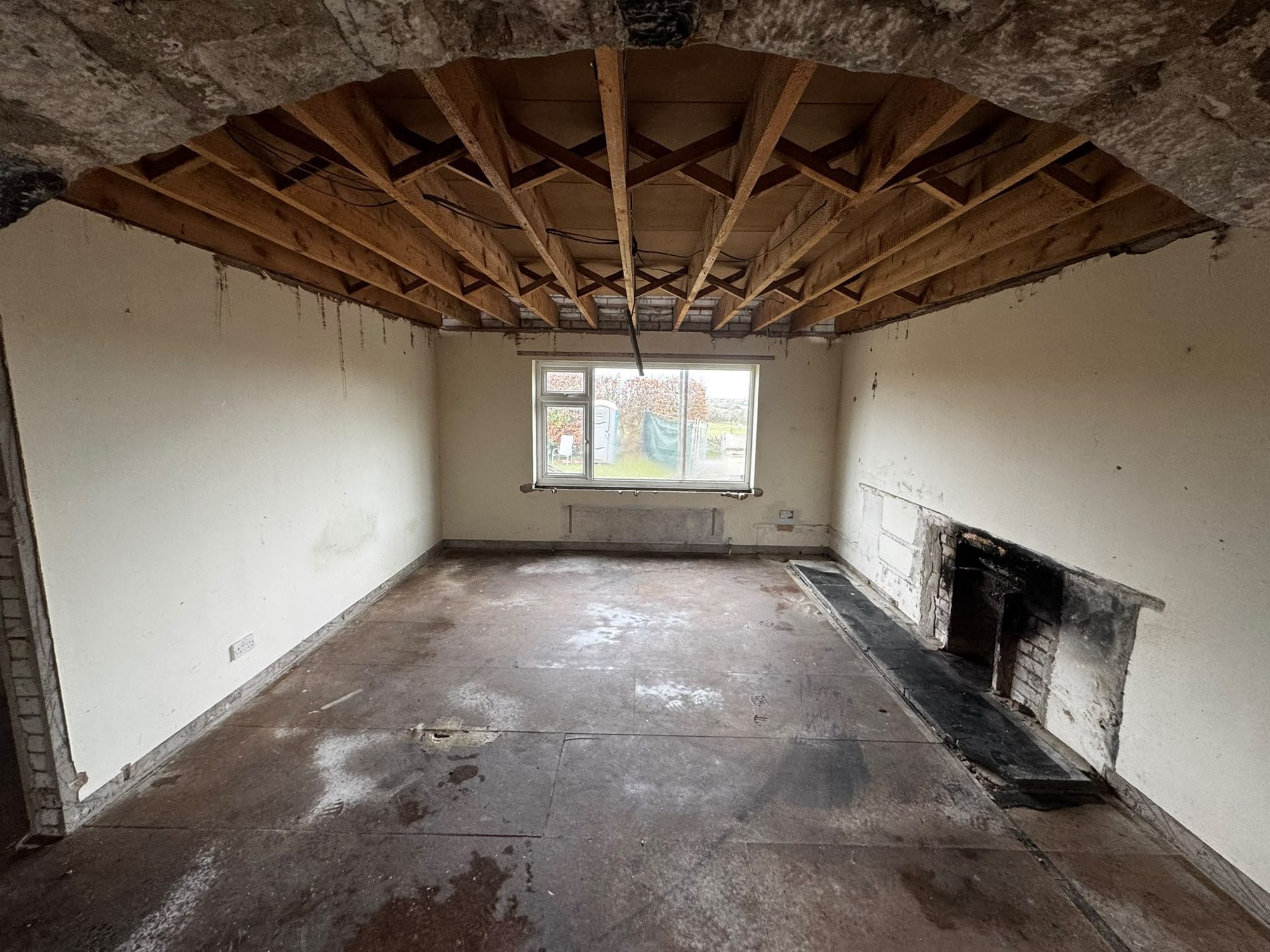 Living room soft strip with ceiling removed to joists in Anglesey